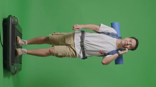 Full Body Of Asian Male Hiker Talking On Smartphone While Walking On A Treadmill On Green Screen
