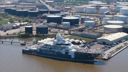 Grand yacht de luxe en construction dans un chantier naval avec grues, assemblage de navires