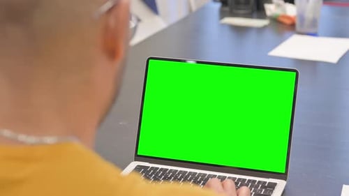 Hispanic Man Using Laptop with Green Screen