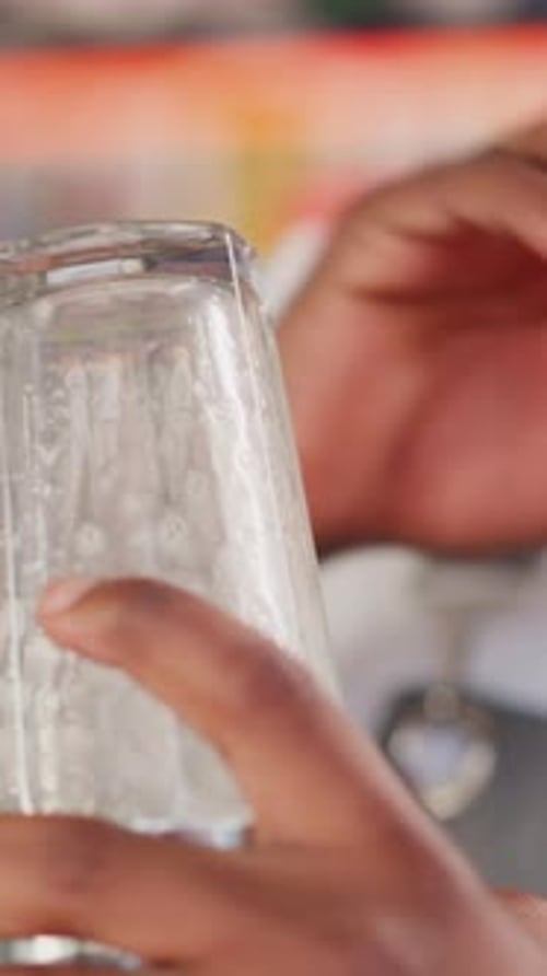 Barkeep Bumps Glass with Elbow in Bar