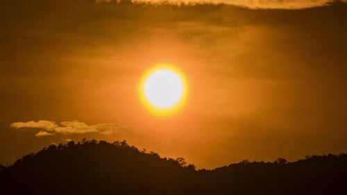 Timelapse of dramatic sunset with orange sky in a cloudy day.