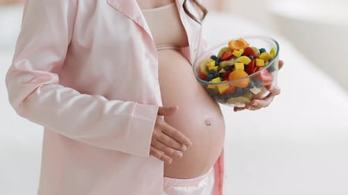 Pregnant Woman Holding Bowl of Colorful Fruit Salad