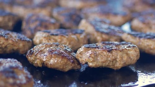 Delicious and Savory Grilled Meat Patties are Sizzling Enticingly on a Barbeque Grill