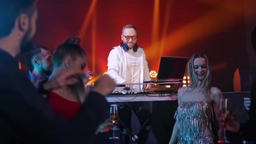 Clubbing People Dancing on Crowded Dance Floor Famous DJ Live Performance Illuminated Party Slowmo