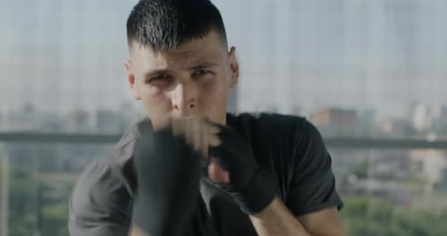 Focused Young Man Boxing in Urban Gym Setting