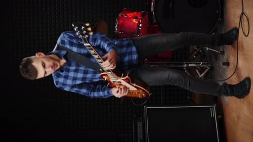 Professional musician playing on electric guitar, performing solo at concert. Vertical video