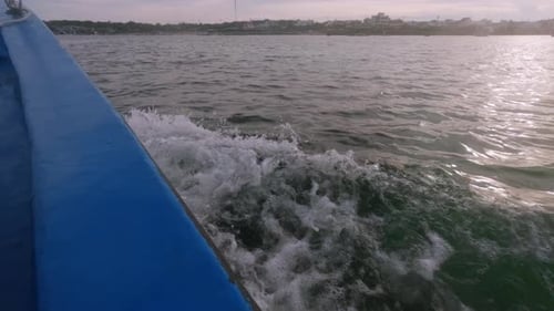 Salpicando agua al costado de un barco que viaja al atardecer. Foto POV