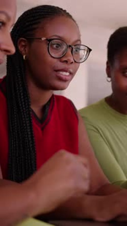 Three Young Women Discuss Work at Desk
