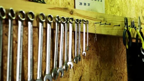 La
main humaine est accrochée à un pied à coulisse mural. Outils mécaniques accrochés au mur