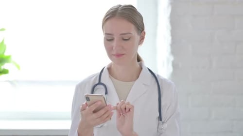 Young Doctor Using Smartphone in Bright Room