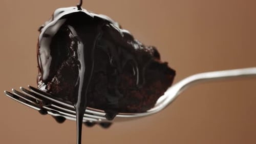 Chocolate Sauce Drips on Rich Brownie on Fork