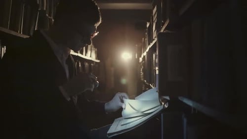 Young Adult Reading Old Book with Magnifying Glass