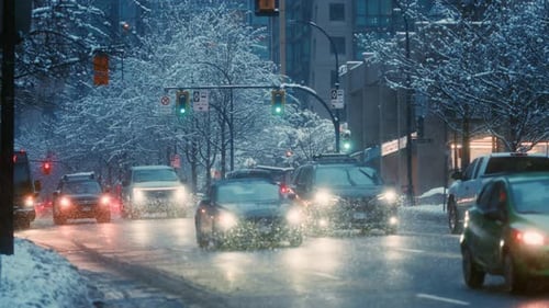 Schneesturm in Zeitlupe, verschneite Straßen mit Verkehrsbussen und Autos, geschmückt mit leuchtenden Ampeln