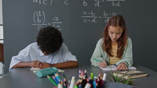 African American Boy and Caucasian Girl Working on Math Problems in School