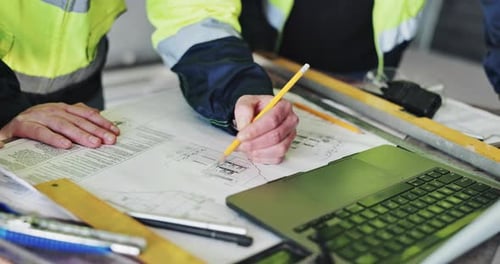 Architects Reviewing Blueprints at Workplace