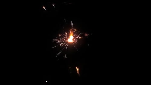 Burning Sparkler Creates Silver and Orange Sparks