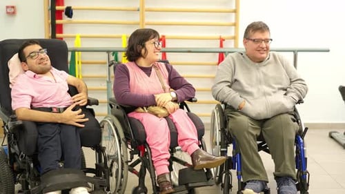 Adults in Wheelchairs Laughing in a Therapy Room