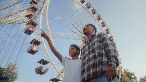 Boy Standing By Man While Having Fun By Observation Wheel