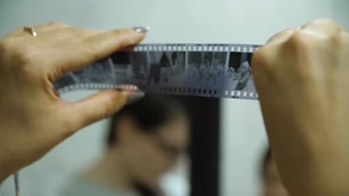 Hands Delicately Holding a Film Strip That is in Vibrant Motion Conveying Creativity and Artistry