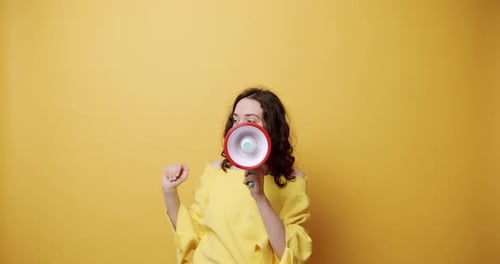 Woman Speaking Into Megaphone on Yellow Background