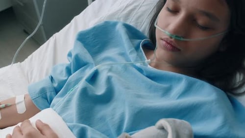 Little Girl with Nasal Cannula Being on IV While Sleeping in Ward