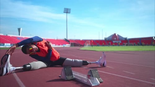 Disabled athletic man stretching and warming up before running on stadium track