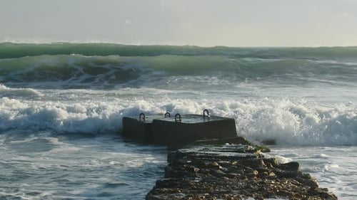 Mar. Las olas rompen protegiendo el espolón.