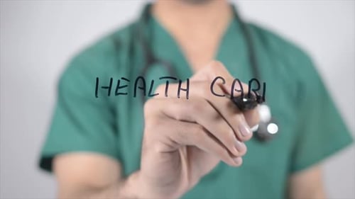 Doctor Writes 'Health Care' on Glass Surface