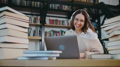 Junges Mädchen, Studentin, sitzt am Schreibtisch, benutzt PC, Laptop, Computer, schaut Online-Fernunterricht