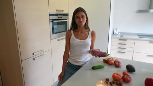 Woman Juggle Eggplant in Bright Modern Kitchen