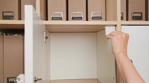 A woman installs a magnetic lock on the closet door to protect the child