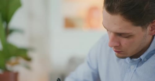 Young Man Writing with a Pen Close Up