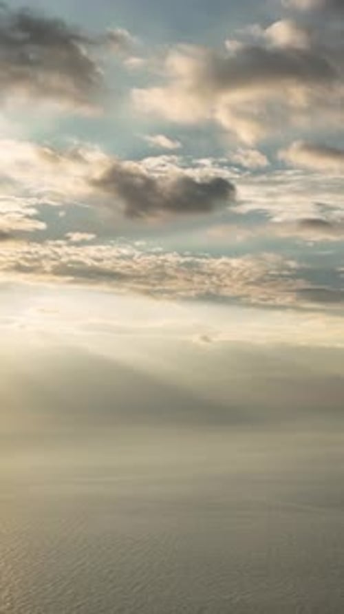 Vidéo verticale enchanteresse du crépuscule montrant des rayons du soleil embrassant la mer sereine au coucher du soleil