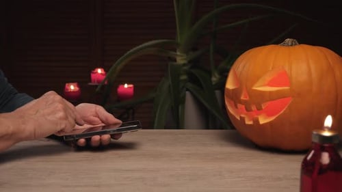 A man changes the lights inside a Halloween lantern
