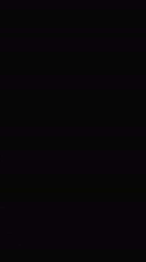 Vertical video of white sand grains thrown in air and copy space on black background