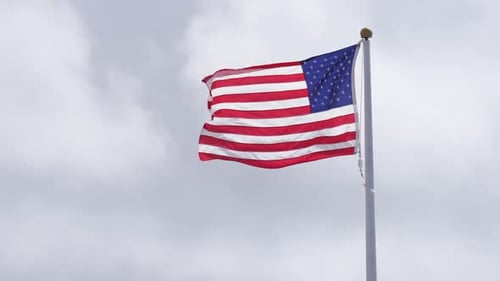 Waving American Flag with Cloudy Sky Background