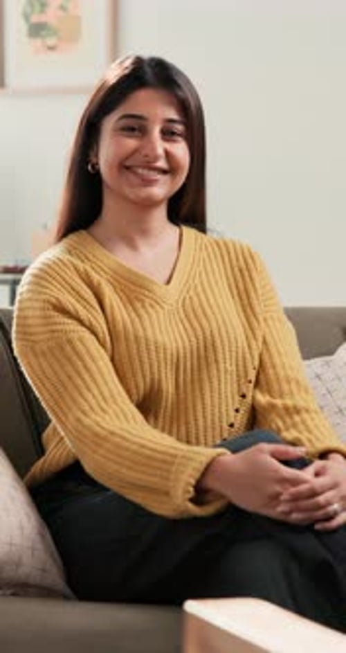 Smiling Woman Sitting on Sofa in Cozy Home