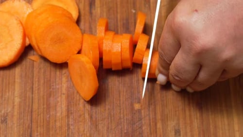 Cutting Fresh Carrot on Wooden Cutting Board