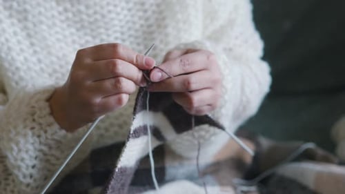 Close up of Hands Knitting Gray Yarn Indoors