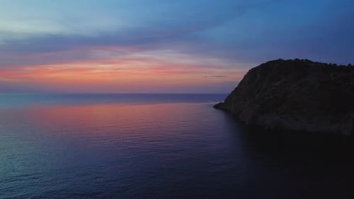 Sunset view over rocky coastline on a calm summer evening