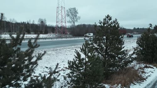 Stunning Aerial Footage Showcasing a Beautiful Snowy Landscape Featuring a Highway and Tall Pine
