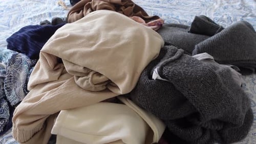 Pile of Clothes Scattered on Patterned Bed