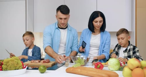 Family Prepares Food Together in a Bright Kitchen