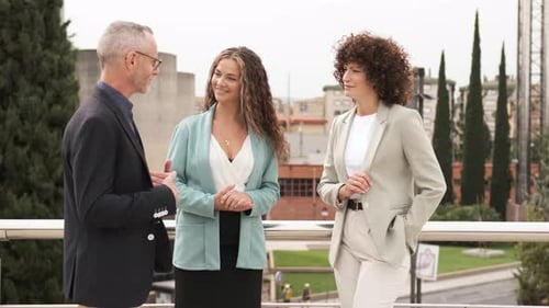 Colegas de trabalho felizes discutindo no terraço do edifício