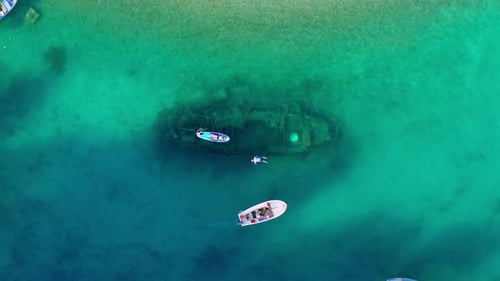 Tourists Snorkeling and Paddleboarding Over Shipwreck in Croatia