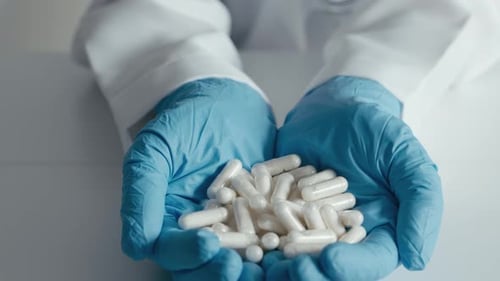 Medical Professional Holding Pile of Pills in Hands