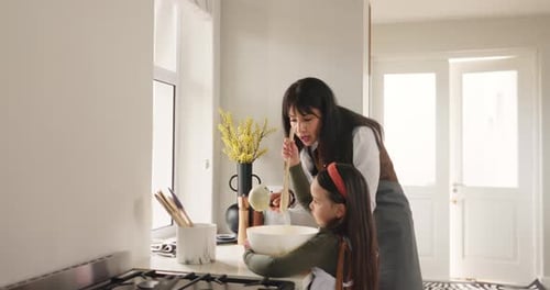 Woman and Girl Baking Together in Bright Kitchen