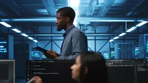 Technician Uses Tablet in Modern Server Room