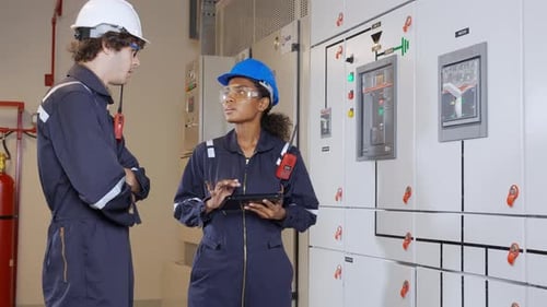 Engineers Inspecting Electrical Power Distribution Center