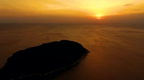 Orange sunset over the sea. The sun is setting over the horizon. Evening view of the mountains and s